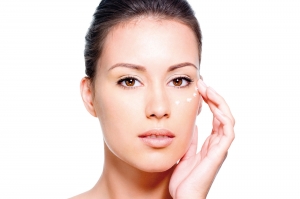 Mujer aplicándose crema en el rostro